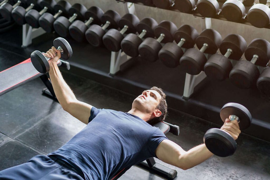 Vücut geliştirme sürecinde akşam yemeği ve metabolizma ilişkisini simgeleyen, spor salonunda fitness hareketleri yapan sporcu.