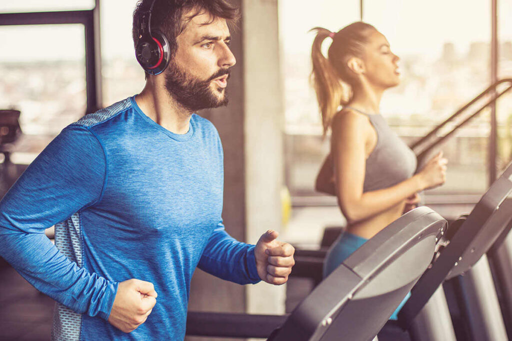 Spor ve beslenme makaleleri kapsamında antrenman motivasyonunu artıran müzikler eşliğinde fitness hareketleri yapan sporcu.